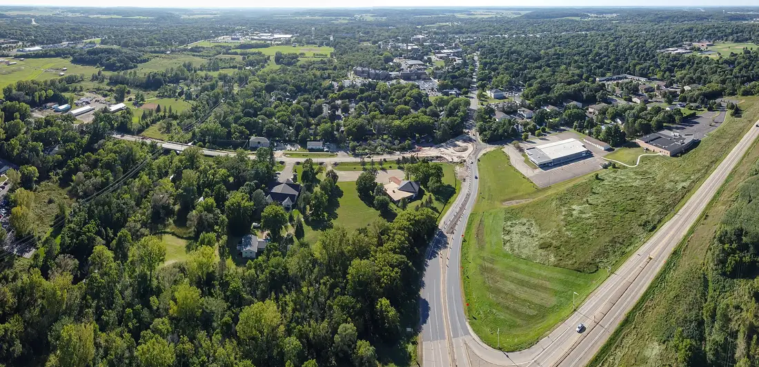 Aerial view of River Falls, Wisconsin, with houses among trees beside a curving highway